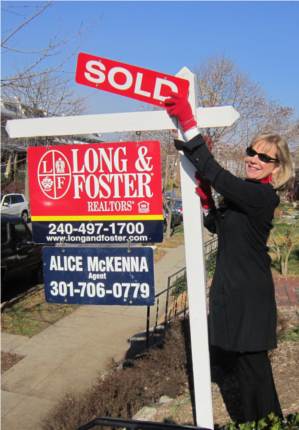 Alice standing with sold sign